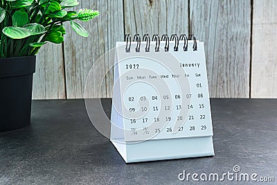 White January 2022 calendar with potted plant on wooden table Stock Photo