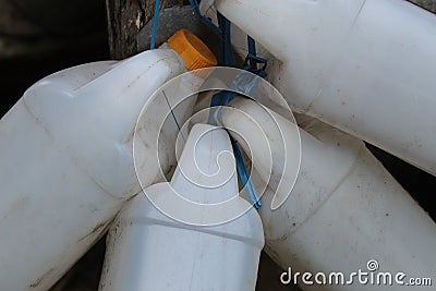 white jerry cans are usually used to fill various types of liquids, tied together and hung Stock Photo