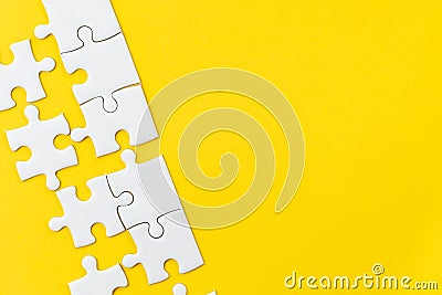 White jigsaw puzzle on vivid yellow background with copy space using for thinking strategy for business solution, teamwork, Stock Photo
