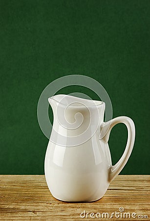 White jug on old wooden table Stock Photo