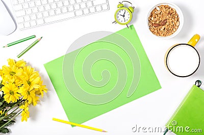 White keyboard, colorful stationery, yellow flowers, plate with granola and large cup of milk on white background. Stock Photo