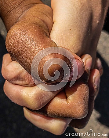 White kid and black kid holding hands Stock Photo