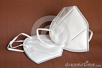 White KN95 or N95 mask for protection against coronavirus on brown background. Surgical protective mask. Stock Photo