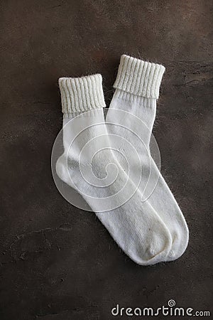 White knitted natural wool socks on a beige and gray table. Stock Photo