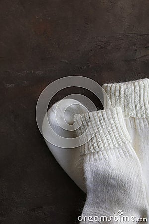 White knitted natural wool socks on a beige and gray table. Stock Photo