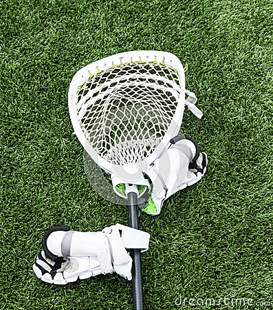 Lacrosse goalie stick with hgloves on turf field Stock Photo