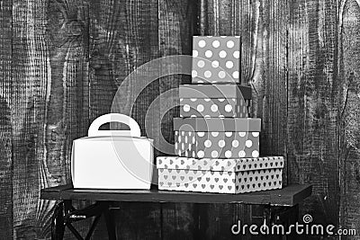 White ladies handbag and pretty sweet presents boxes on black tray on wooden background, copy space. Stock Photo