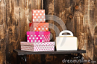 White ladies handbag and pretty sweet presents boxes on black tray on wooden background, copy space. Stock Photo