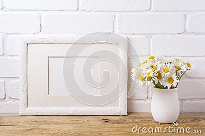 White landscape frame mockup with chamomile bouquet in rustic va Stock Photo