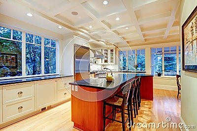 White large luxury kitchen with huge wood island and refrigerator. Stock Photo