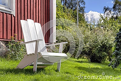 White lawn chair in summer garden Stock Photo