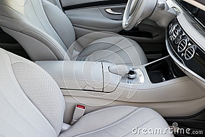 White leather interior of the luxury modern car. Leather comfortable white seats and multimedia. Steering wheel and dashboard. Stock Photo