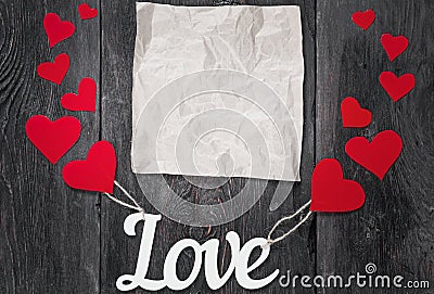 White letters Love with red hearts in a rustic style. space for text on crumpled craft paper. Stock Photo