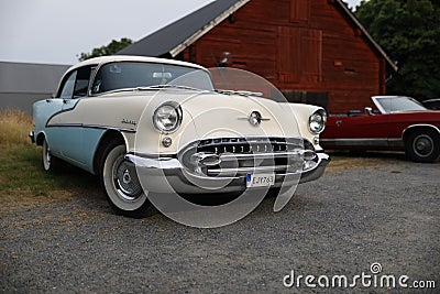 White and Light Blue Oldsmobile S-88 with Round Headlights and Chrome Front Grille Editorial Stock Photo