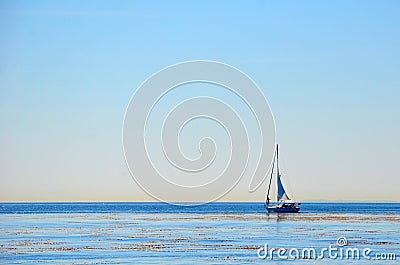 A white lonely yacht is sailing along the shoreline Stock Photo