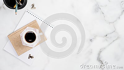 White marble home office desk with paper notebook, stationer and cup of coffee. Minimal flat lay style composition with copy space Stock Photo