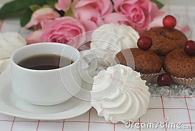 White marshmallows, chocolate muffins, a cup of coffee and roses. Stock Photo