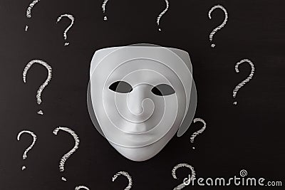 White mask on black with question marks. Stock Photo