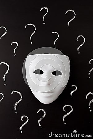 White mask on black with question marks vertical Stock Photo