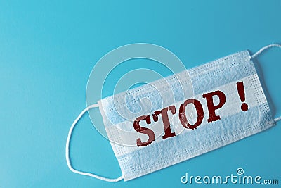 White medical mask with the inscription STOP, blue background Stock Photo