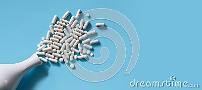 White medical pills and capsules or vitamines on blue background. Copy space. Stock Photo