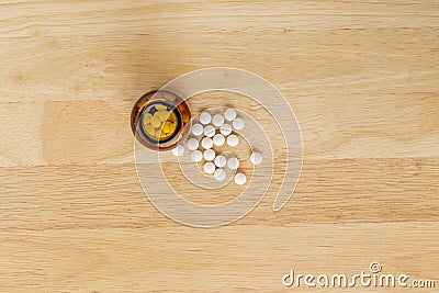 White medicinal antibiotics and glass bottle on a wooden background Stock Photo