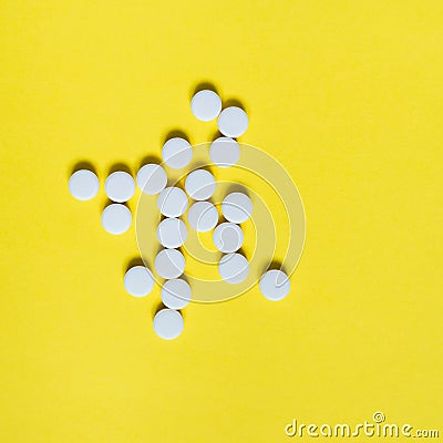 White medicine pills on yellow background. Medical and healthcare concept Stock Photo