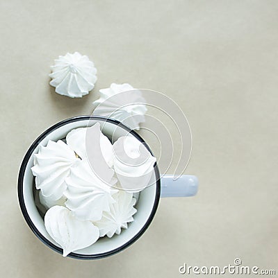 The white merengues in a cup on beige background top view Stock Photo