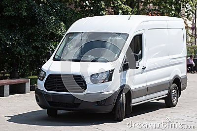 white minibus is parked in city street Stock Photo