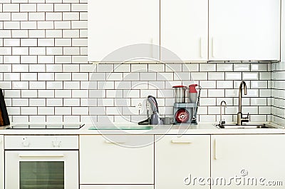 White minimalistic kitchen interior and design. Tile wall background. Household appliances - blender, vacuum machine Stock Photo