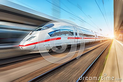 White modern high speed train in motion on railway station Stock Photo