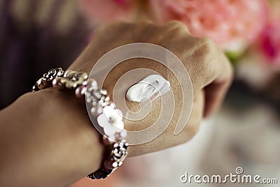 White moisturizer on a woman`s hand. Blurred background. Stock Photo