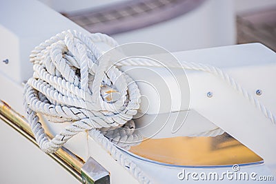 White nautical rope tied on cleat of modern yacht deck Stock Photo