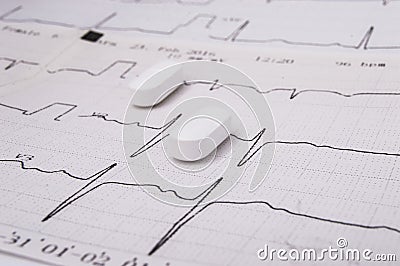White oblong pills or tablets for treatment of diseases of the cardiovascular system as an option - statin lie on the paper elec Stock Photo