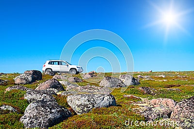 White off-road vehicle on peak of green hill Stock Photo