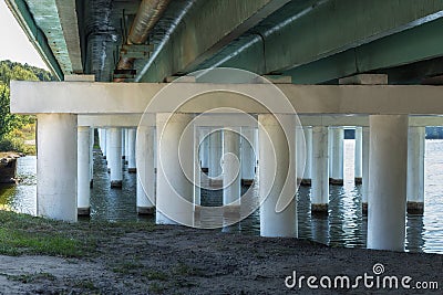 White Ñoncrete bridge supports across the river. Under the bridge Stock Photo