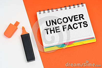 On a white-orange surface lies a marker and a notepad with the inscription - UNCOVER THE FACTS Stock Photo