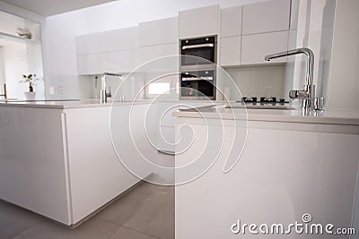 White organised kitchen with modern elements in an apartment Stock Photo