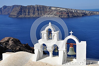 White orthodox church bells in Santorini island, Greece, view to santorini caldera Stock Photo