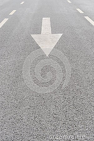 White painted arrow on grey asphalt road Stock Photo