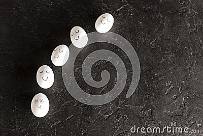 White painted eggs lying on a black background. Teamwork. Leadership. While others sleep one works hard Stock Photo