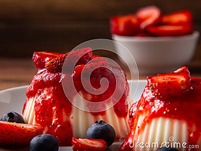 White panna cotta with strawberry in a dish on a wooden background Stock Photo