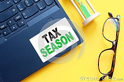 White paper with text TAX SEASON in male hands on a white background Stock Photo