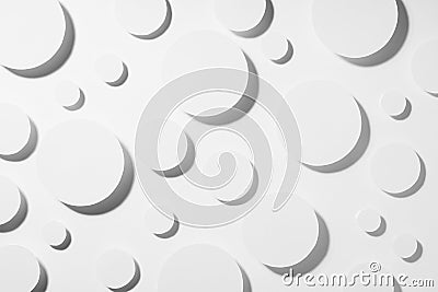 White paper circles different size as abstract random pattern in hard light with grey strict shadows, top view. Contemporary. Stock Photo