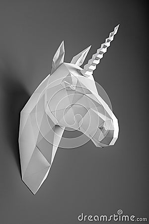 White paper geometrical shaped unicorn`s head hanging on black wall. Stock Photo