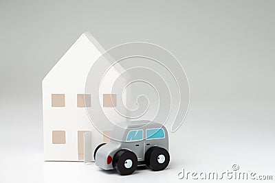 White paper house and cute wooden car on white gray background w Stock Photo