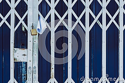 White paper notification attached to closed retractable folding metallic gate.Metal collapsible sliding grille door normally use Stock Photo