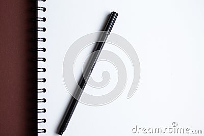 White paper spiral notebook and black pen Stock Photo