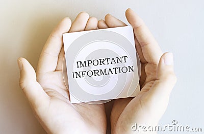 White paper with text Important Information in male hands on a white background Stock Photo