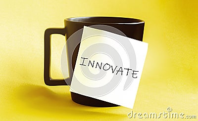 White paper with text INNOVATE on the black cup Stock Photo